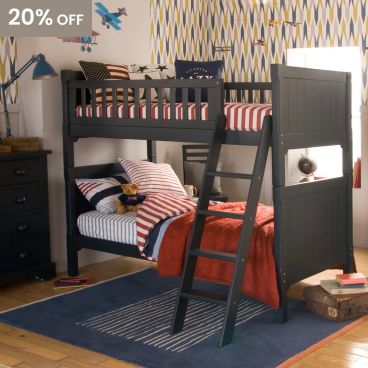 Traditional dark blue boys bunk bed, with red and blue bedding and geometric wallpaper 