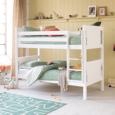 White classic beech detachable bunk bed in pink and orange themed bohemian girls room, with spotty wallpaper and bedding, wicker chair 