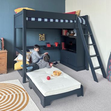 Navy high sleeper loft bed with unfolded futon, kids gaming and games console inside bookcase, in blue and cream bedroom