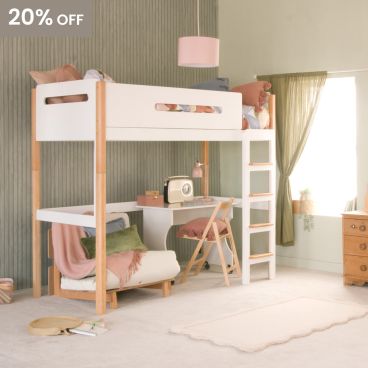 A two tone beech and white loft high sleeper bed with a futon chair, desk and study chair underneath. There are green panelled walls, a green curtain hanging at the window and a pink ceiling lampshade 
