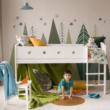 Cubix mid sleeper bed with boy playing underneath and hand painted trees on wall 