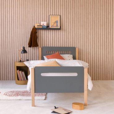 natural and anthracite two tone children's bed with curved corners and pill shape cut outs in the head and foot boards in modern room with wood effect wallpaper