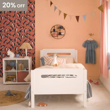 end view of white bed with rounded corners and pill shape cut outs, in bedroom with cat wallpaper