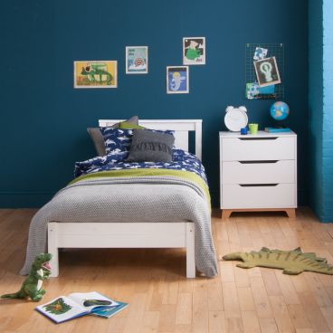 white bed and chest of drawers in blue bedroom, seaside themed. 