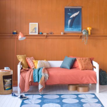 white pill cut out day bed against tongue and groove painted wall