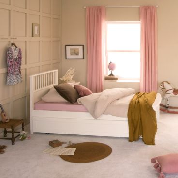 white single bed with trundle underneath, stool, rocking horse and child's belongings