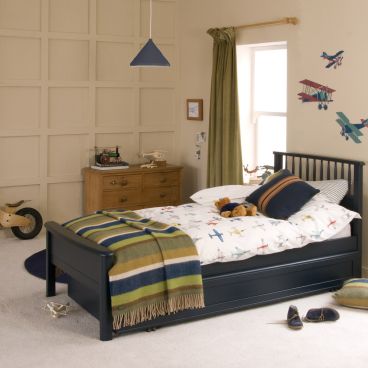 blue single bed with trundle underneath, chest of drawers and child's belongings