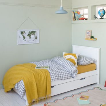 Boys white single bed in superhero room with desk and red chair