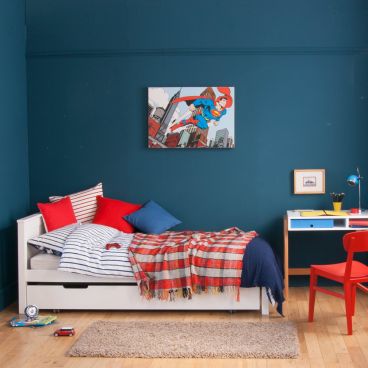 Boys white single bed in superhero room with desk and red chair