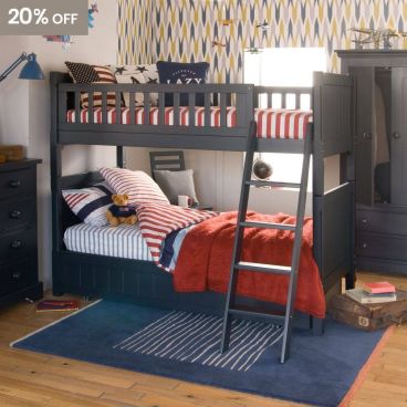 Large dark blue bunk bed with trundle tucked underneath and pitched ladder, Chest of drawers next to it and vintage planes on the wall.