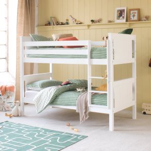 White classic beech detachable bunk bed in pink and orange themed bohemian girls room, with spotty wallpaper and bedding, wicker chair 