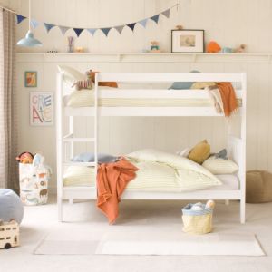 front view of Pip ranch style bunk bed in Pure White, with blue bunting above and orange and blue room accessories