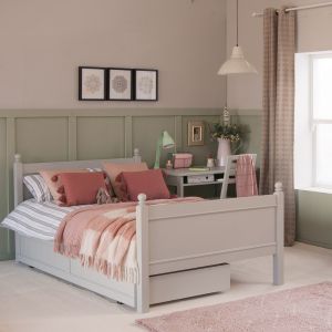 grey small double bed in green panelled bedroom and with pink accessories