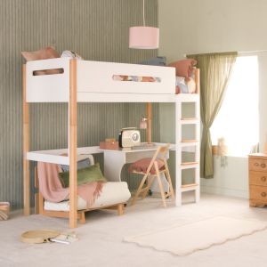 A two tone beech and white loft high sleeper bed with a futon chair, desk and study chair underneath. There are green panelled walls, a green curtain hanging at the window and a pink ceiling lampshade 