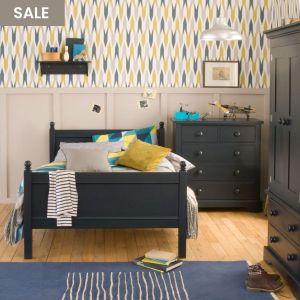 child's navy bed, chest of drawers, wardrobe straight on to camera in blue and yellow bedroom