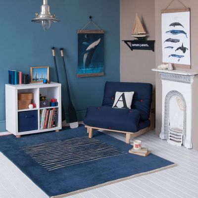 Blue Futon chair bed with red buttons, in nautical bedroom nautical themed corner in kids room, blue futon chair bed, storage, blue and caramel scheme